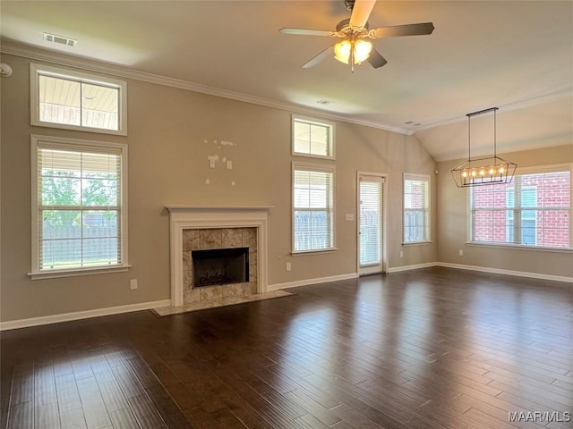 9145 Autumn Brooke Way, Montgomery, AL 36117 - unfurnished living room featuring a tiled fireplace, ornamental molding, ceiling fan, a chandelier, and dark wood-type flooring