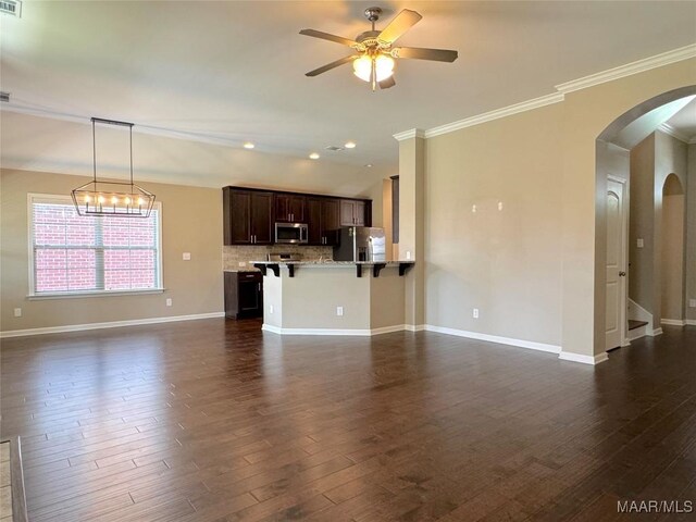 9145 Autumn Brooke Way, Montgomery, AL 36117 - unfurnished living room with arched walkways, crown molding, dark wood finished floors, a ceiling fan, and recessed lighting