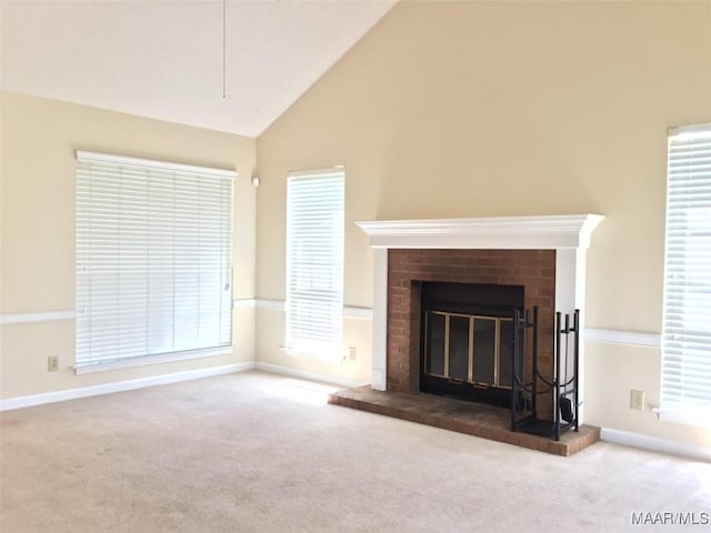 unfurnished living room with a brick fireplace, carpet floors, baseboards, and high vaulted ceiling