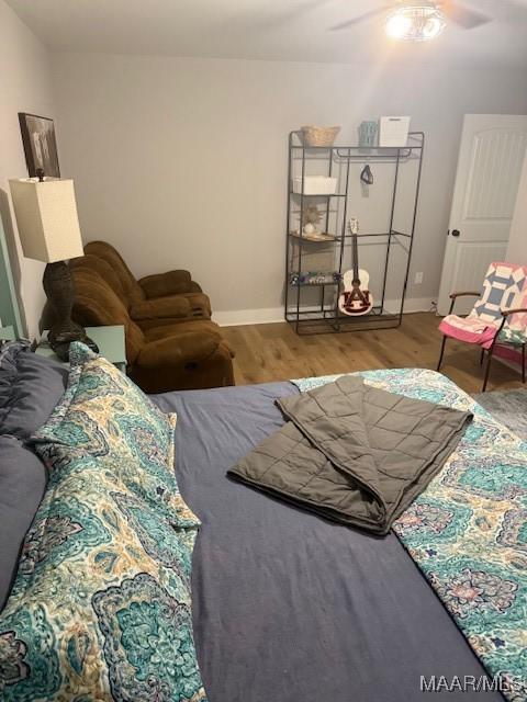 bedroom featuring wood finished floors, baseboards, and a ceiling fan