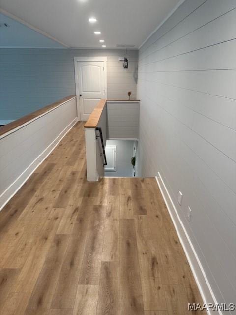 washroom with wood finished floors, wood walls, and baseboards
