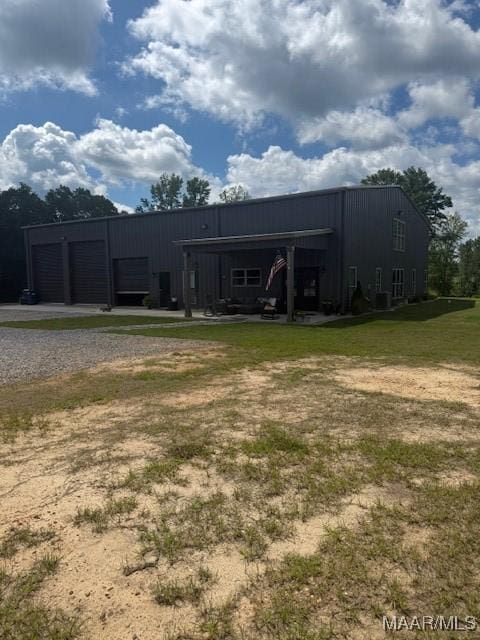 rear view of house featuring driveway and a yard