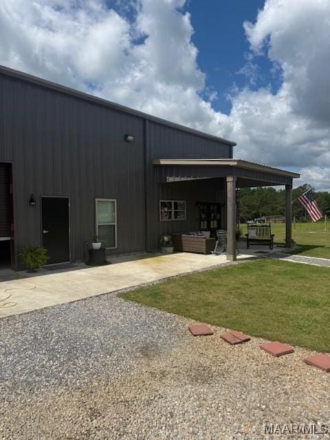 rear view of property featuring a patio, a yard, and outdoor lounge area