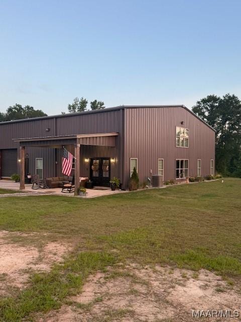 2533 Weldon Rd, Tallassee, AL 36078 - rear view of house featuring a lawn, a detached garage, and a patio