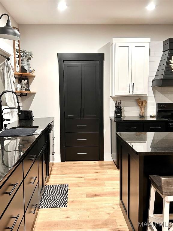 2533 Weldon Rd, Tallassee, AL 36078 - kitchen featuring custom range hood, open shelves, stove, light wood finished floors, and decorative backsplash