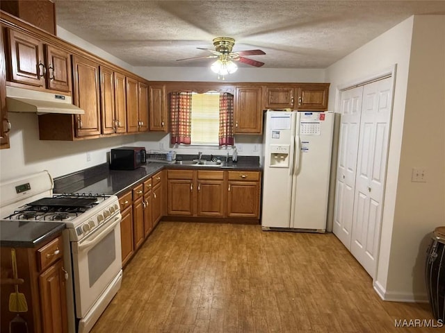 176 Lawrence Cv, Valley Grande, AL 36703 - kitchen featuring white appliances, under cabinet range hood, light wood-style floors, dark countertops, and a textured ceiling