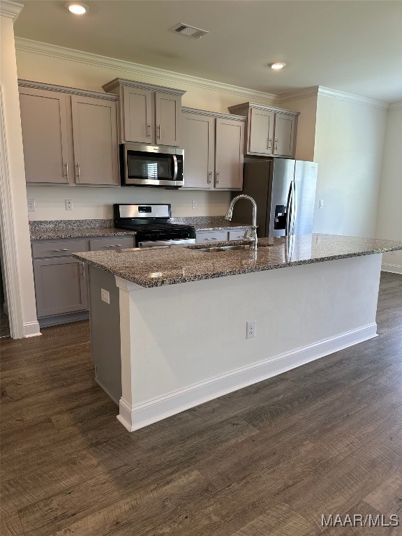 5168 Sedona Dr, Montgomery, AL 36116 - kitchen with stainless steel appliances, gray cabinetry, a kitchen island with sink, crown molding, and dark wood-style flooring
