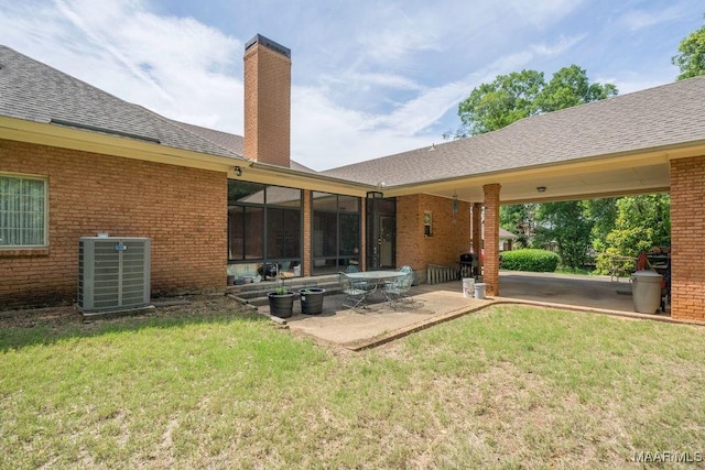 rear view of house featuring central AC, a patio area, a chimney, and brick siding