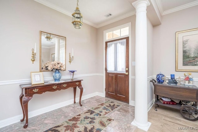foyer entrance featuring ornate columns, ornamental molding, and baseboards