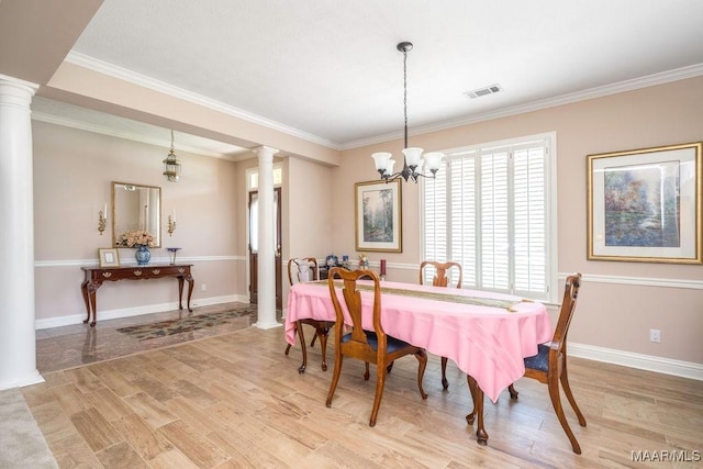 dining room with decorative columns, light wood-style flooring, a chandelier, crown molding, and baseboards