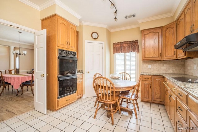 kitchen with black appliances, under cabinet range hood, tasteful backsplash, crown molding, and a chandelier