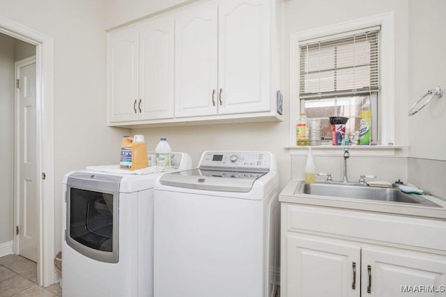 laundry area with independent washer and dryer, cabinet space, and light tile patterned floors