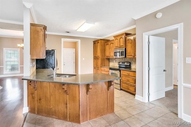 612 Coleman Way, Prattville, AL 36067 - kitchen featuring stainless steel appliances, a sink, a kitchen bar, brown cabinets, and a peninsula