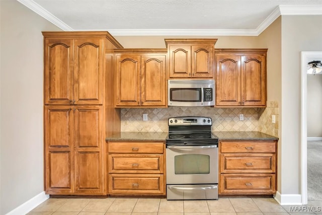 612 Coleman Way, Prattville, AL 36067 - kitchen with stainless steel appliances, baseboards, brown cabinetry, tasteful backsplash, and ornamental molding