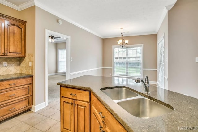612 Coleman Way, Prattville, AL 36067 - kitchen with a sink, dark stone countertops, brown cabinets, plenty of natural light, and ornamental molding
