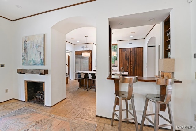 1777 Barganier Rd, Cecil, AL 36013 - kitchen with stone tile flooring, arched walkways, stainless steel built in fridge, a breakfast bar, and crown molding