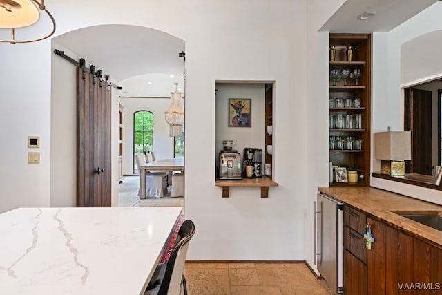 1777 Barganier Rd, Cecil, AL 36013 - bar area with a barn door, baseboards, arched walkways, and stone tile floors