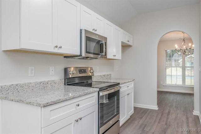 176 Stoneridge Dr, Tallassee, AL 36078 - kitchen featuring appliances with stainless steel finishes, arched walkways, wood finished floors, a chandelier, and white cabinetry