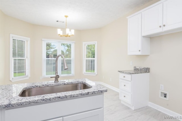 2224 Halcyon Blvd, Montgomery, AL 36117 - kitchen featuring a sink, light stone counters, and a chandelier