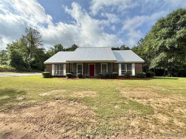 419 County Road 16, Valley Grande, AL 36701 - view of front of house featuring covered porch, a front yard, brick siding, and metal roof