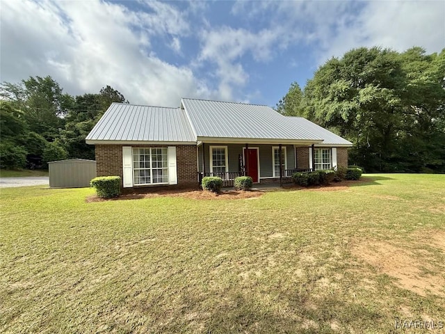 419 County Road 16, Valley Grande, AL 36701 - view of front of house featuring covered porch, brick siding, a front lawn, and metal roof