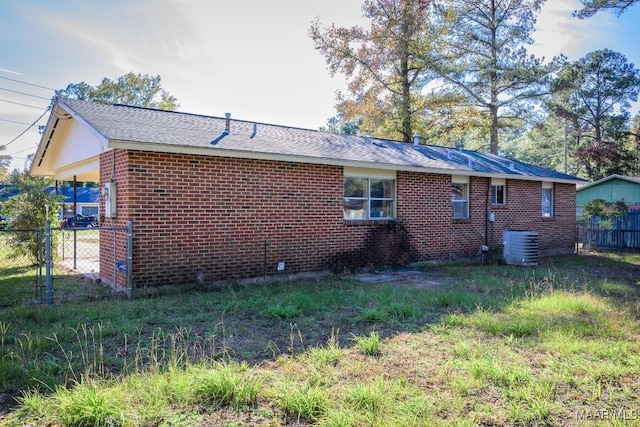 205 9th Ave, Selma, AL 36701 - view of property exterior with fence, brick siding, central AC, and roof with shingles
