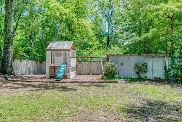 2527 Hermitage Dr, Montgomery, AL 36111 - fenced backyard with a shed, a playground, and an outbuilding