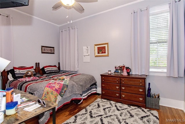 bedroom with ornamental molding, wood finished floors, baseboards, and a ceiling fan