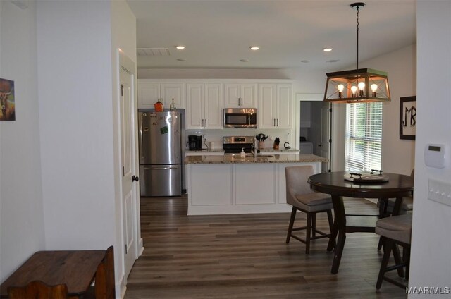 7330 Butler Mill Rd, Ramer, AL 36069 - kitchen with stainless steel appliances, white cabinetry, dark wood-style flooring, a chandelier, and light stone counters