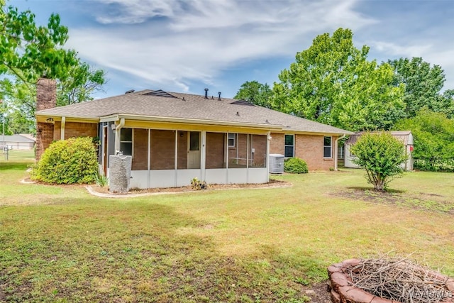 100 Duck Cv, Elmore, AL 36025 - back of house featuring central AC unit, a chimney, a lawn, a sunroom, and brick siding