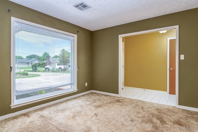 100 Duck Cv, Elmore, AL 36025 - spare room with light carpet, baseboards, a textured ceiling, and light tile patterned flooring