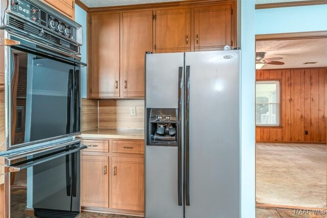 100 Duck Cv, Elmore, AL 36025 - kitchen featuring stainless steel refrigerator with ice dispenser, light countertops, wooden walls, a ceiling fan, and light colored carpet