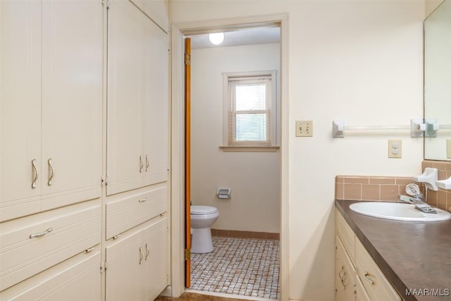 100 Duck Cv, Elmore, AL 36025 - bathroom with vanity, toilet, baseboards, and tasteful backsplash