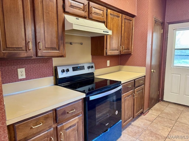 544 Sheila Blvd, Prattville, AL 36066 - kitchen with stainless steel range with electric stovetop, under cabinet range hood, light countertops, wallpapered walls, and light tile patterned flooring