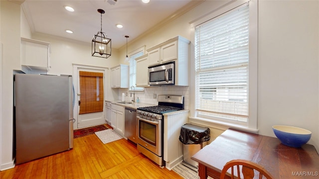 356 Cloverdale Rd, Montgomery, AL 36104 - kitchen with stainless steel appliances, light countertops, tasteful backsplash, white cabinetry, and light wood finished floors