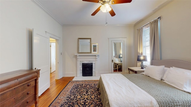 356 Cloverdale Rd, Montgomery, AL 36104 - bedroom with crown molding, light wood-type flooring, a fireplace, baseboards, and a ceiling fan