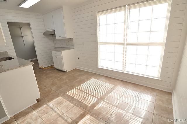 445 Durden Rd, Prattville, AL 36067 - kitchen featuring light tile patterned floors, white cabinetry, light stone countertops, wooden walls, and a sink