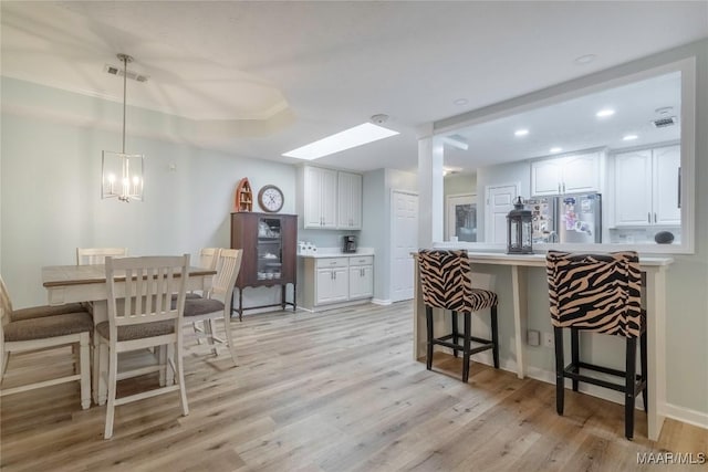 847 Dee Dr, Prattville, AL 36066 - kitchen with freestanding refrigerator, light wood-style floors, a kitchen bar, white cabinets, and recessed lighting