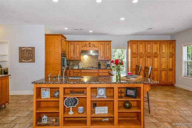 kitchen featuring open shelves, under cabinet range hood, baseboards, a sink, and recessed lighting