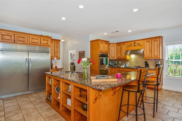 kitchen featuring appliances with stainless steel finishes, a sink, range hood, light tile patterned flooring, and recessed lighting