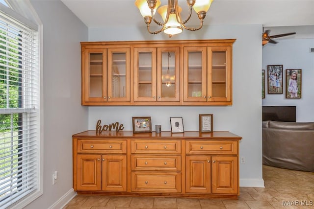 bar area featuring baseboards, a chandelier, and light tile patterned floors
