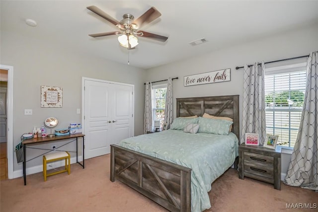 carpeted bedroom with a closet, baseboards, and a ceiling fan