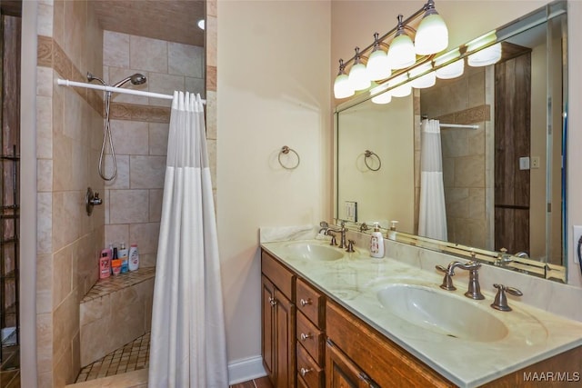 bathroom with a tile shower and double vanity
