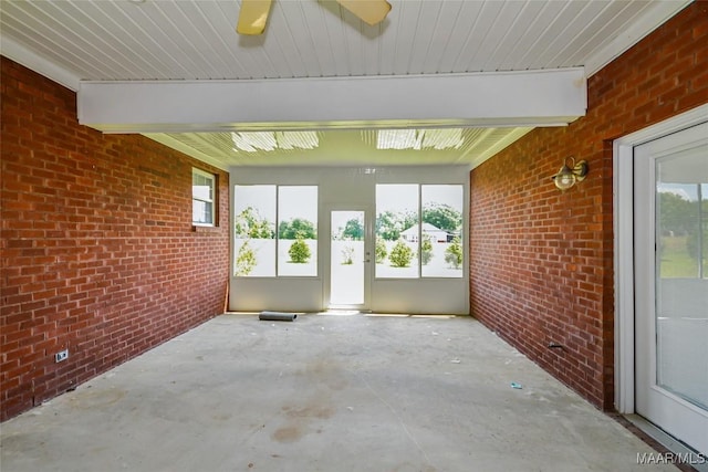 unfurnished sunroom featuring plenty of natural light and beam ceiling