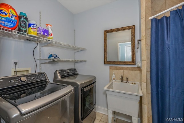 washroom featuring washing machine and dryer, tile patterned flooring, and baseboards