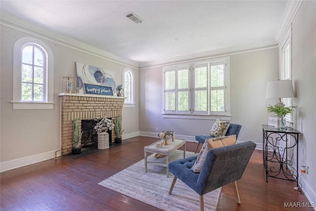 living room featuring ornamental molding, wood finished floors, a brick fireplace, and baseboards