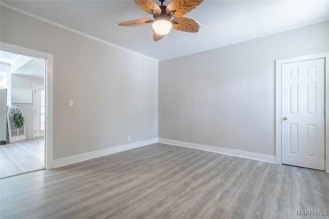 unfurnished room with ceiling fan, wood finished floors, and baseboards
