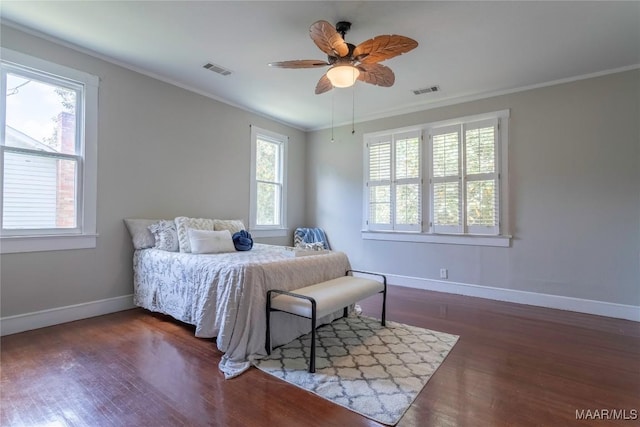 bedroom featuring wood finished floors, baseboards, crown molding, and a ceiling fan