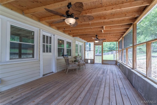 sunroom with a ceiling fan, healthy amount of natural light, and beamed ceiling