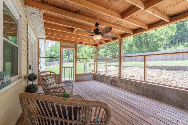 sunroom / solarium featuring ceiling fan, beamed ceiling, and healthy amount of natural light